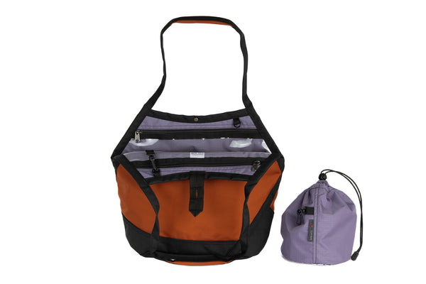 The Swift in Burnt Orange Ballistic with a Dawn (blue-grey with dark blue-grey grid) interior and Medium Yarn Stuff Sack